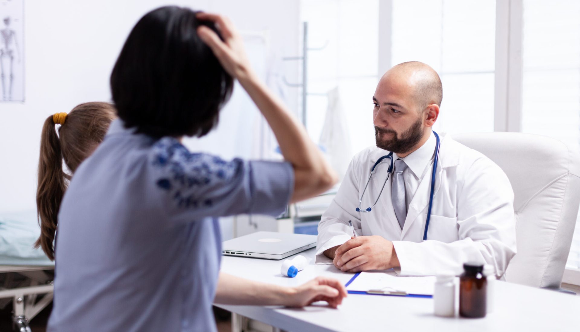 Mother and daughter at doctor appointment in hospital office. Healthcare physician specialist in medicine providing health care services treatment examination.